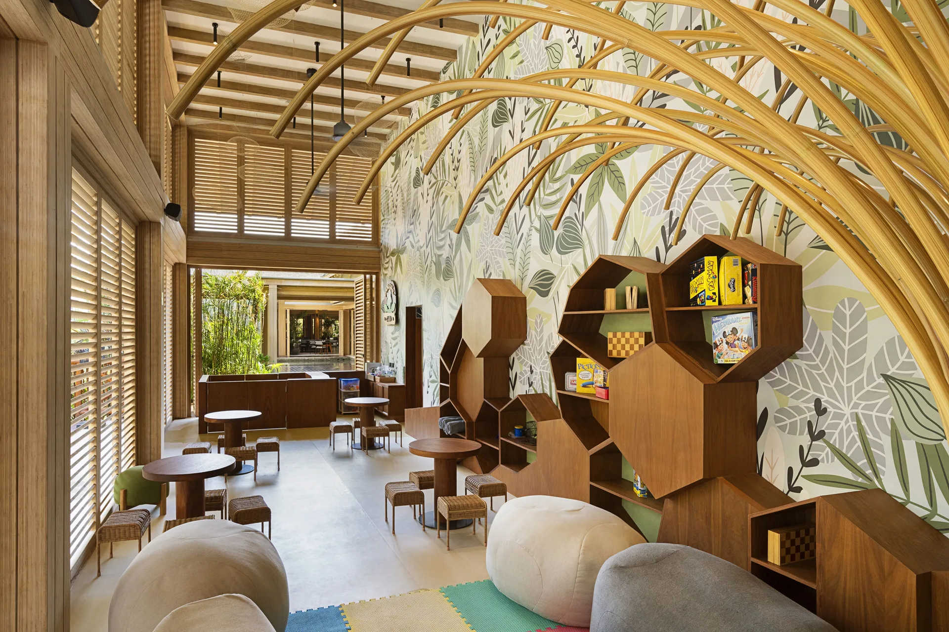 A children’s playroom with tables, shelves, and leaf-patterned walls at Banyan Tree Mayakoba.