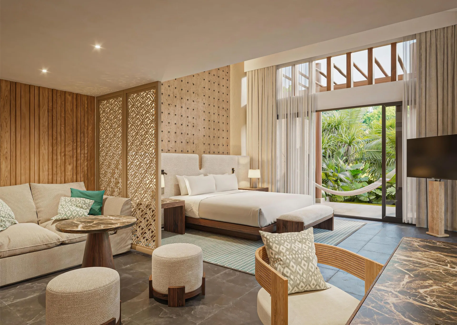 Bliss Pool Villa bedroom and sitting area opening to greenery at Banyan Tree Mayakoba.