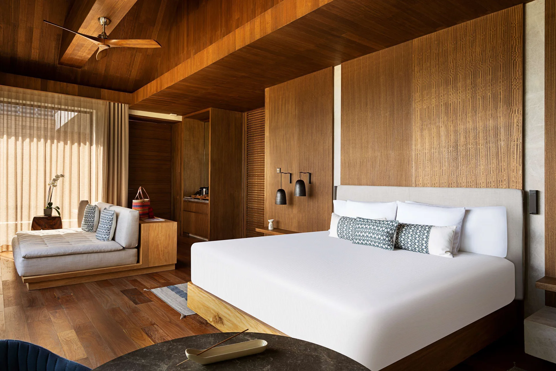 Oceanfront Balcony Pool Suite bedroom with king bed and chaise at Banyan Tree Mayakoba.