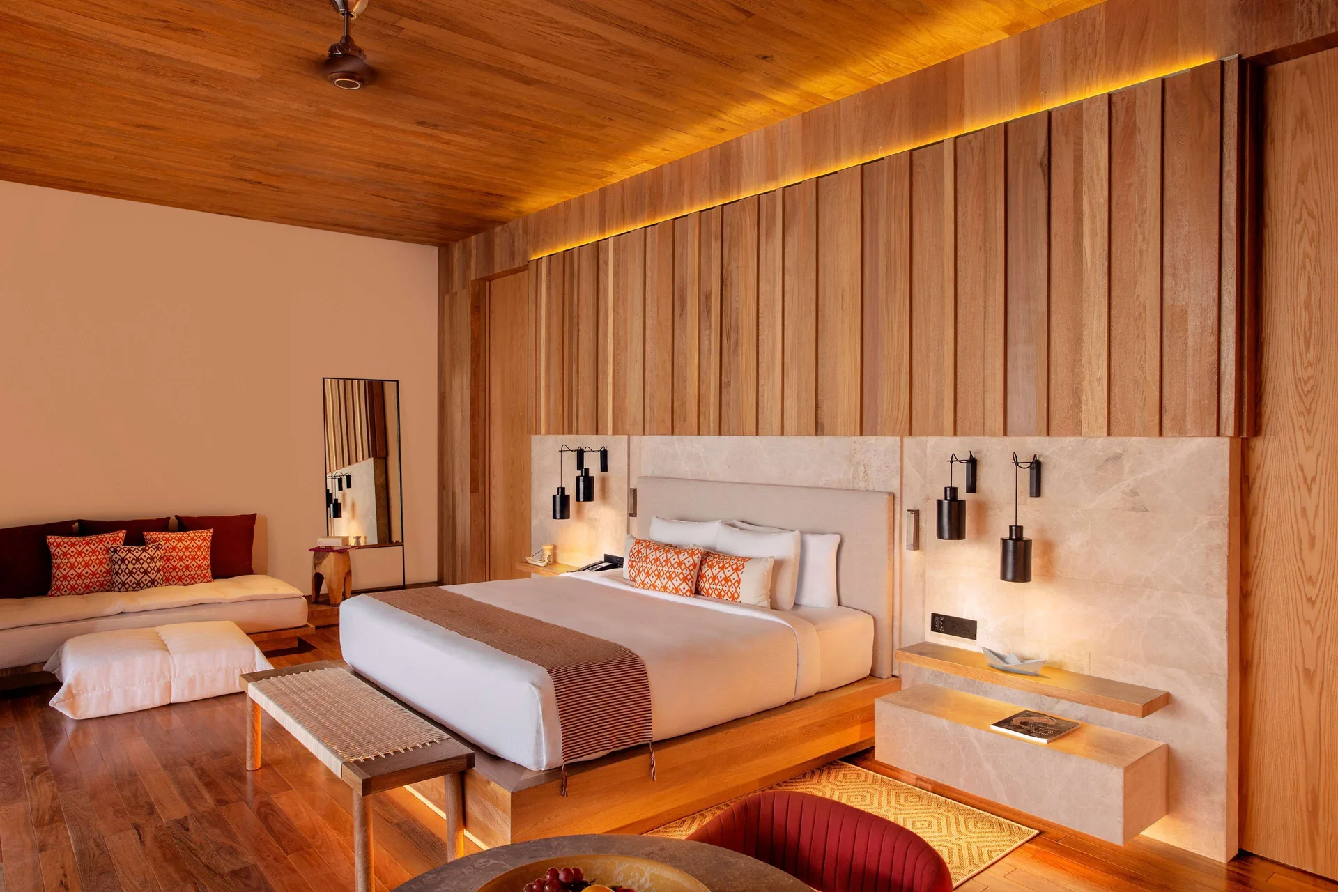 Oceanfront Veranda Pool Suite king bed with wood paneling at Banyan Tree Mayakoba.