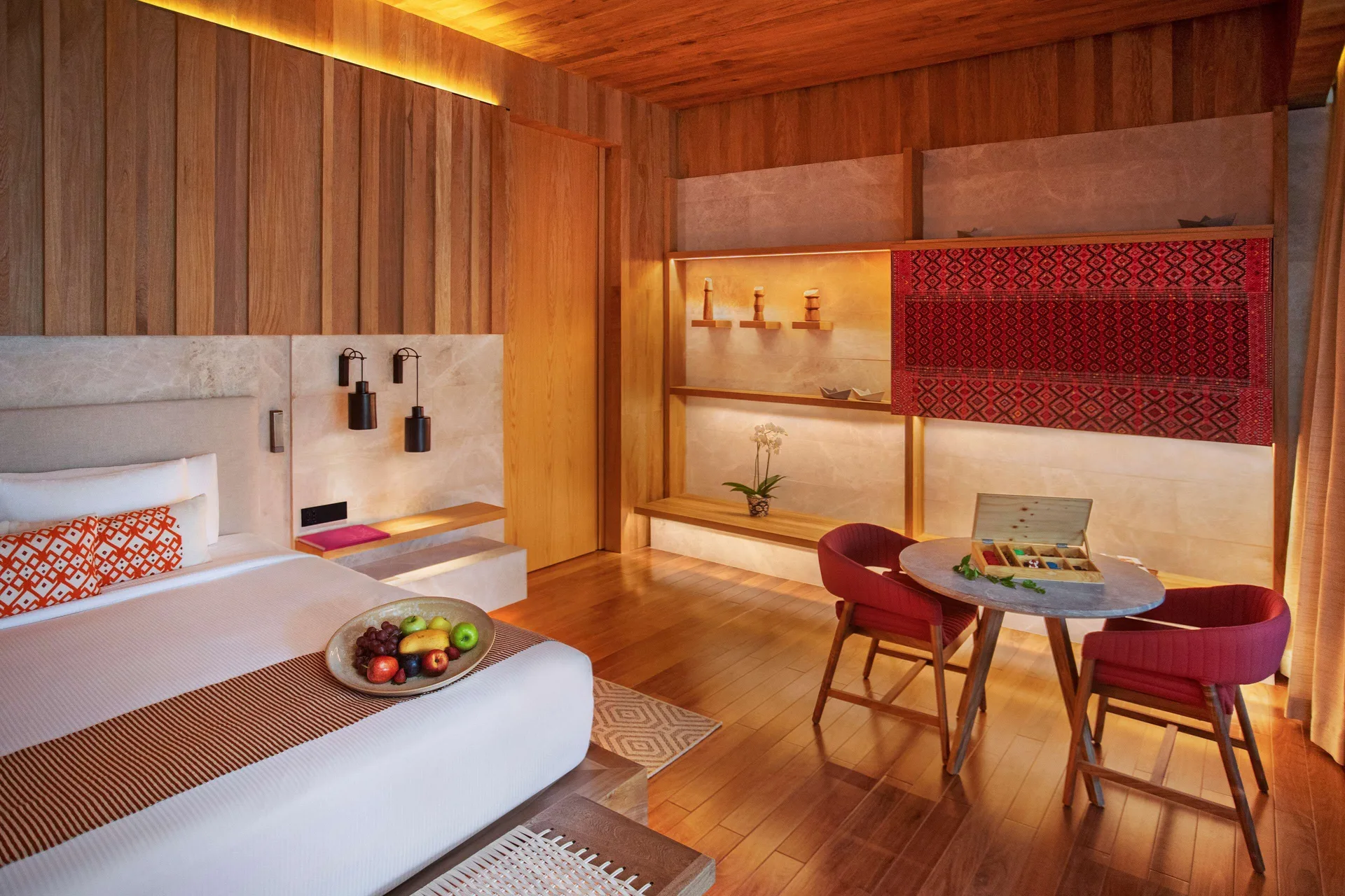 Oceanfront Veranda Pool Suite king bed and dining table with fruit at Banyan Tree Mayakoba.