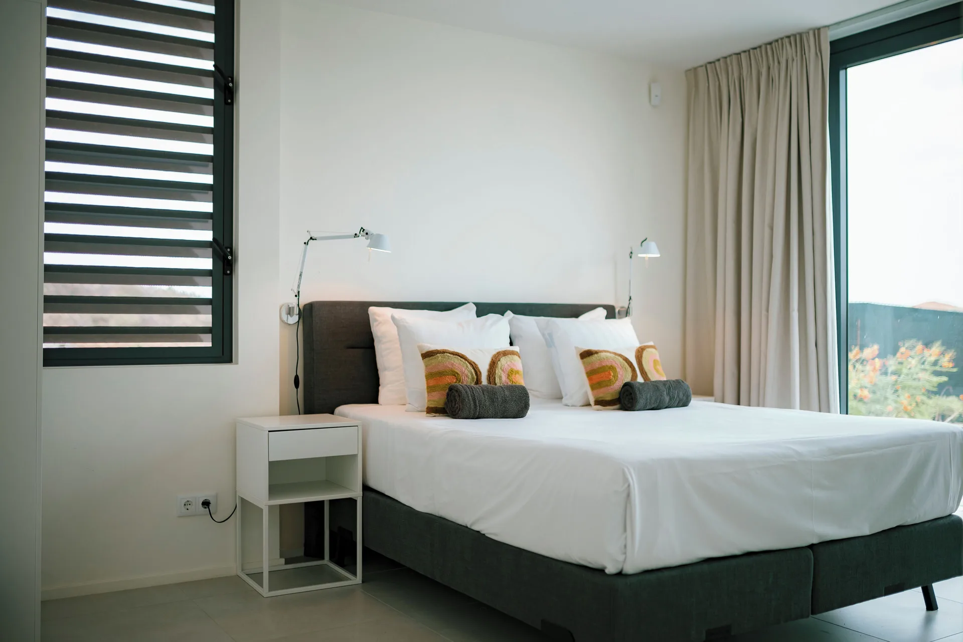 Deluxe Villa bedroom with louvered window at Blue Bay Curacao Golf & Beach Resort.