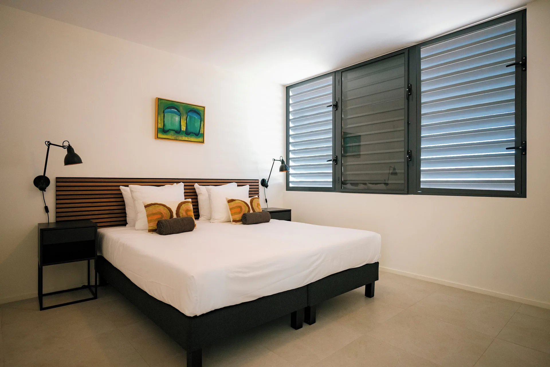 Deluxe Villa bedroom with wall art and shutters at Blue Bay Curacao Golf & Beach Resort.
