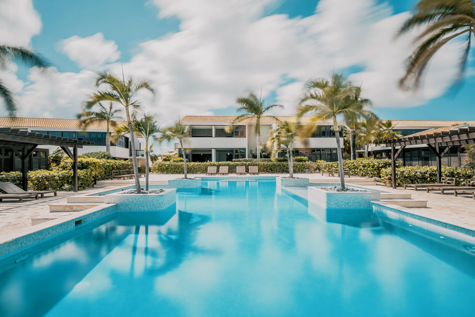 Garden Apartment pool area with palms at Blue Bay Curacao Golf & Beach Resort.