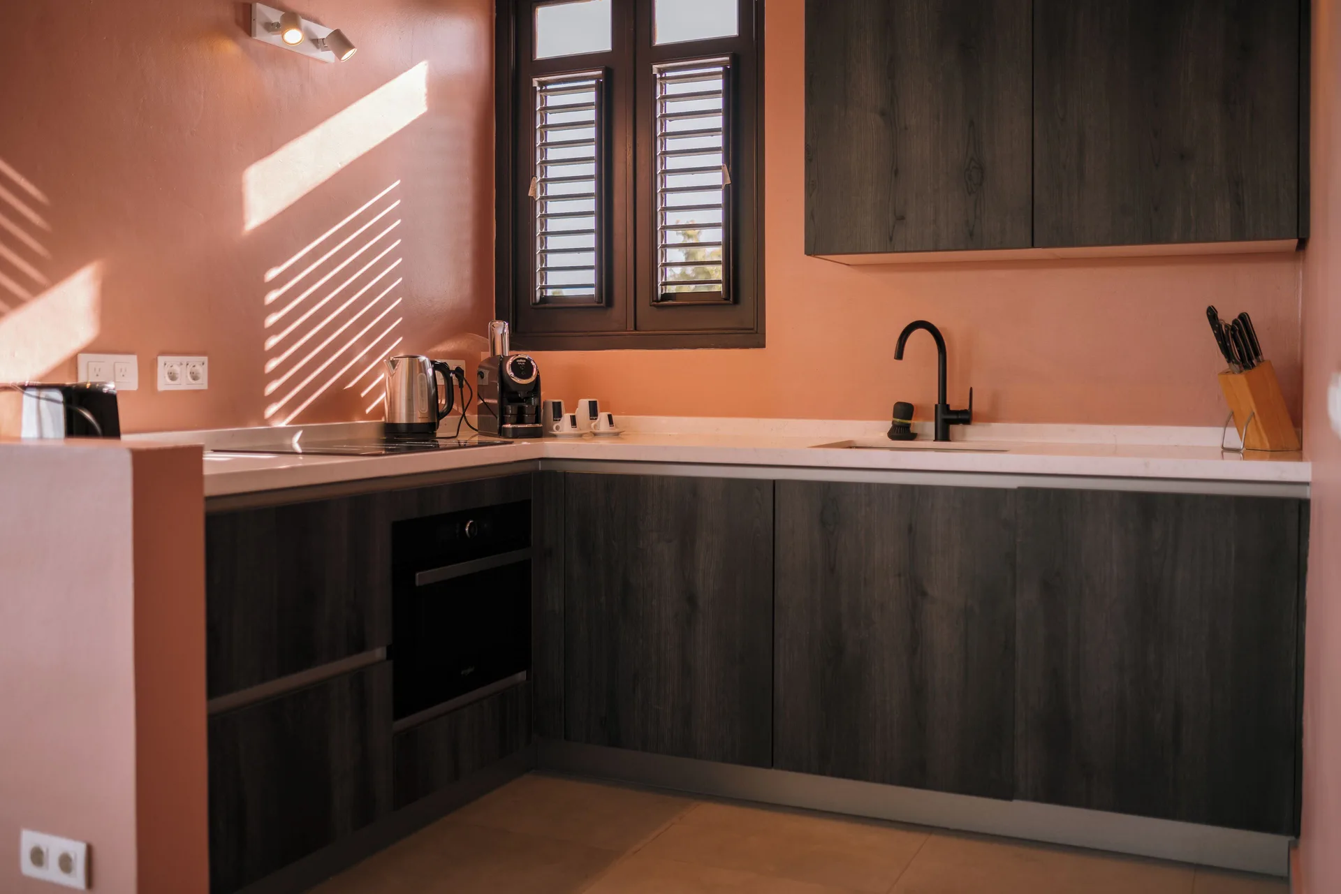 Garden Villa 2 Bedroom kitchen at Blue Bay Curacao Golf & Beach Resort with dark cabinets and window light.
