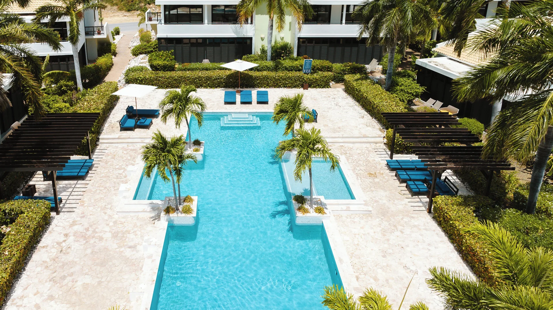 Garden Villa 2 Bedroom pool courtyard at Blue Bay Curacao Golf & Beach Resort with palms and loungers.