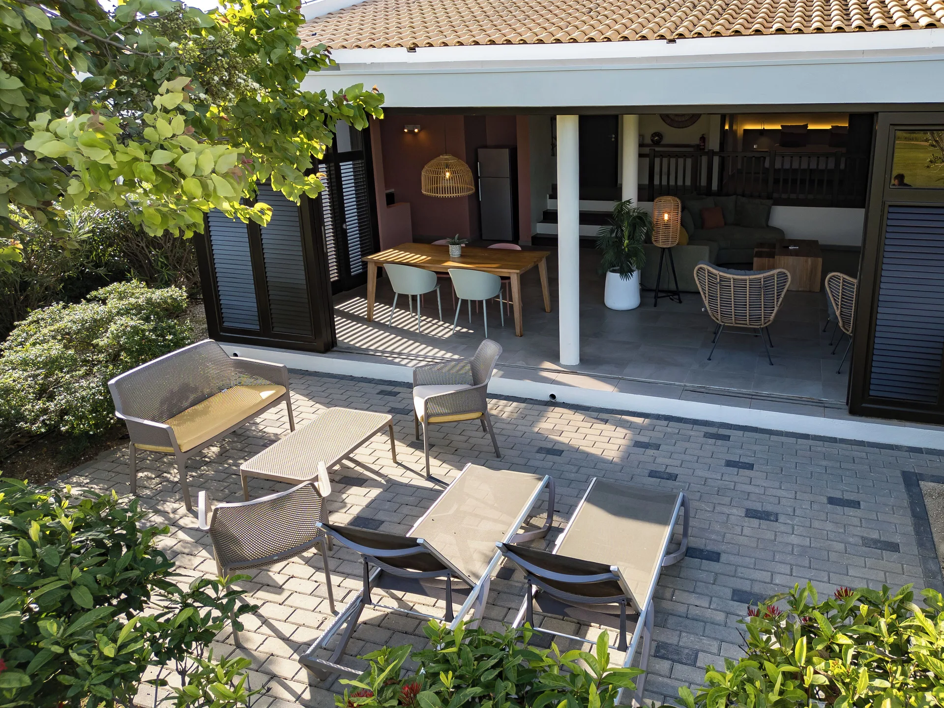 Garden Villa 2 Bedroom terrace at Blue Bay Curacao Golf & Beach Resort with outdoor seating and open doors.