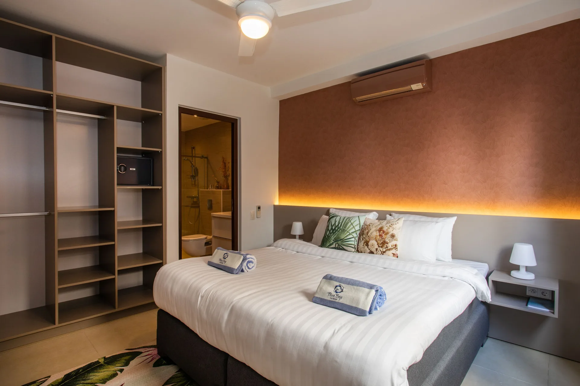 King bedroom in a Greenview apartment at Blue Bay Curacao Golf & Beach Resort with open closet shelving.