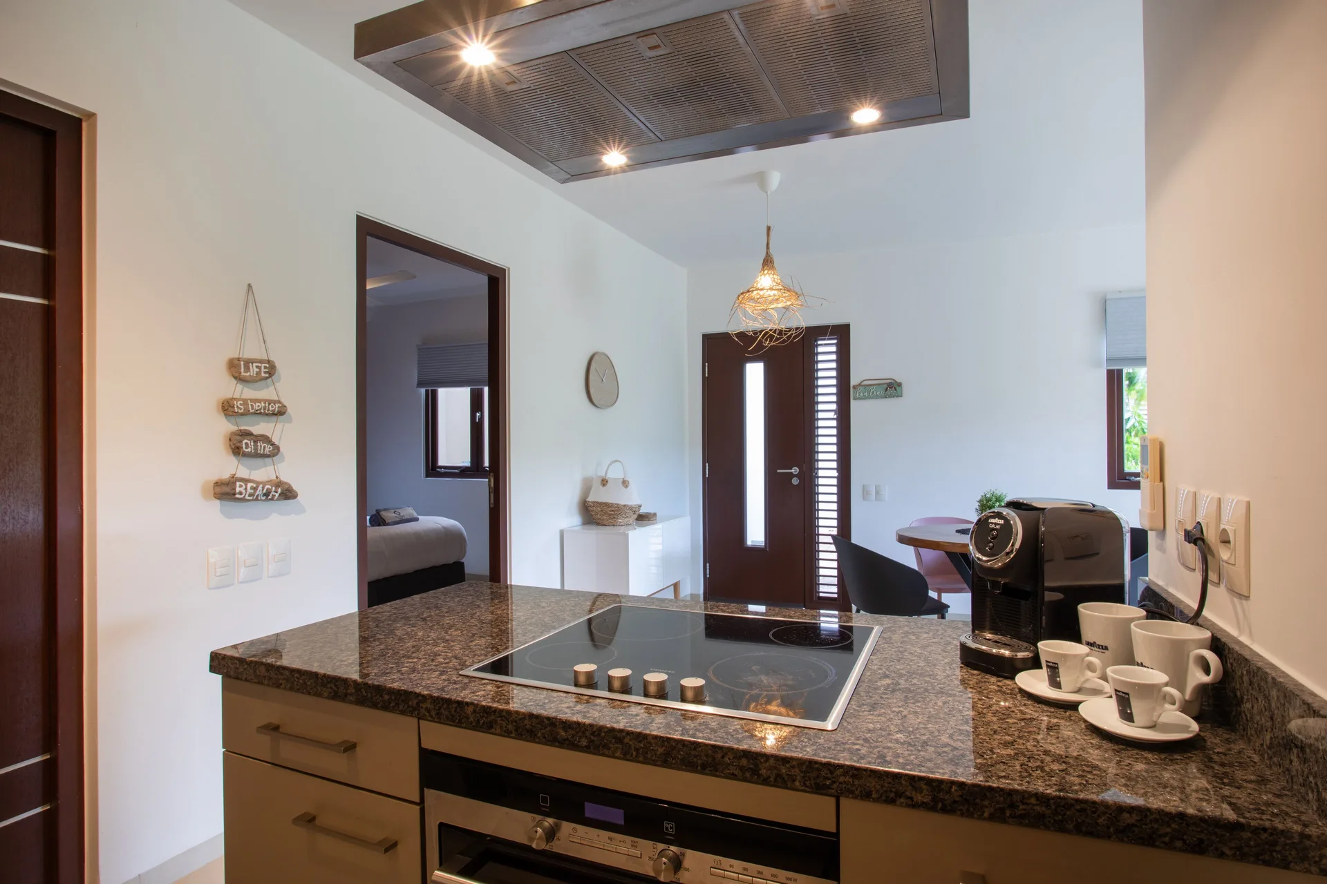 Kitchen counter in a Greenview apartment at Blue Bay Curacao Golf & Beach Resort with cooktop and coffee cups.