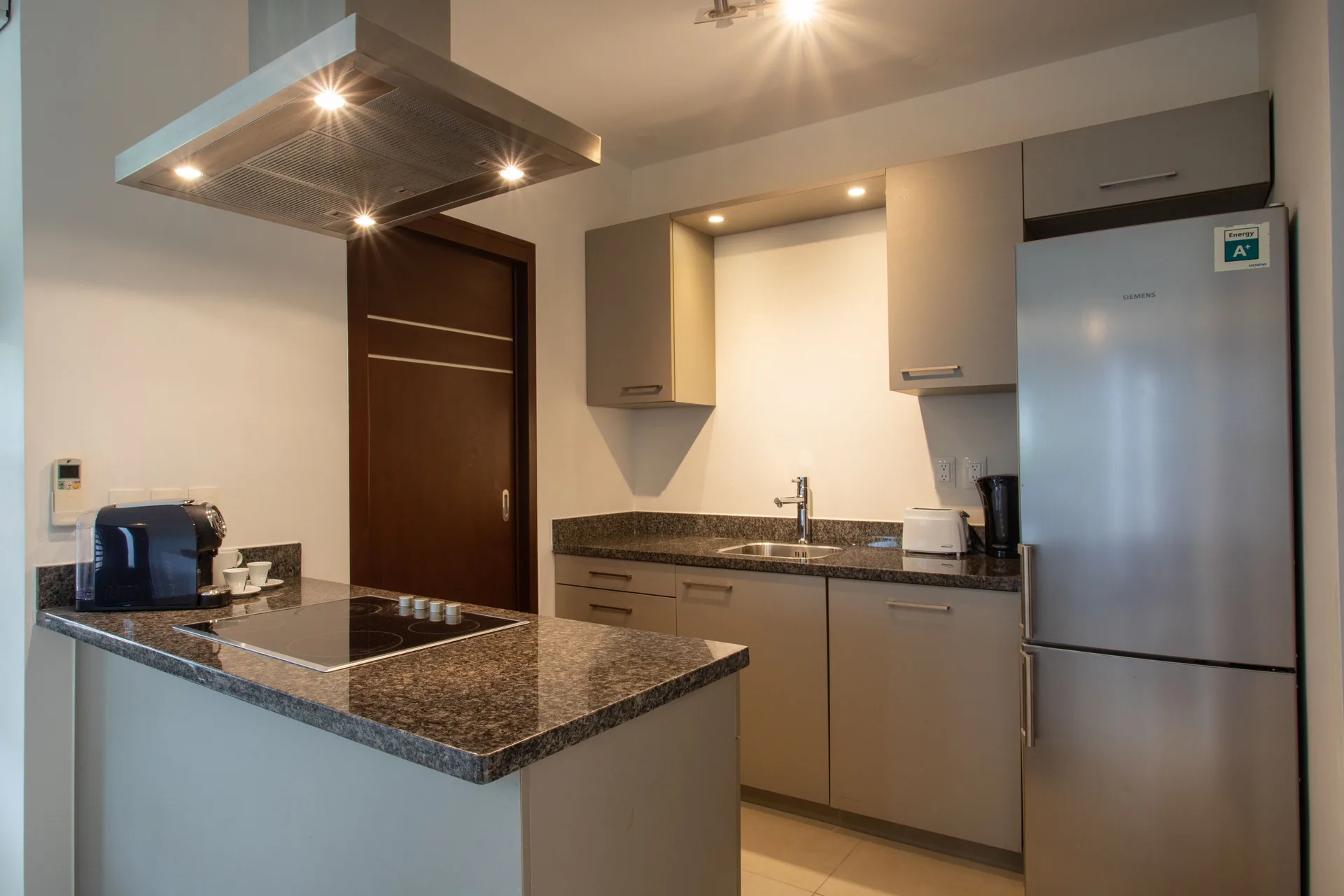 Kitchen in a Greenview apartment at Blue Bay Curacao Golf & Beach Resort with sink, fridge, and cooktop.