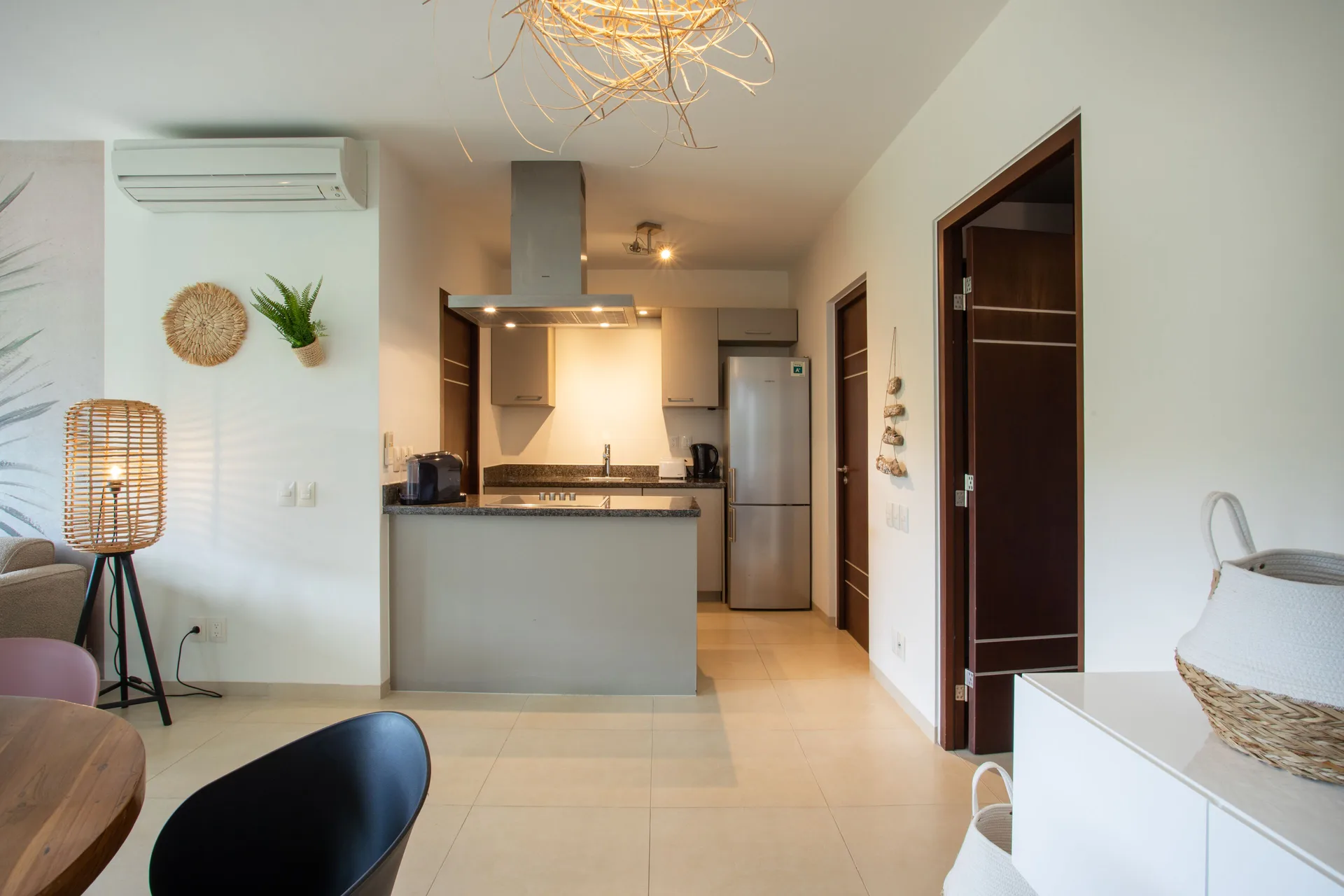 Living and kitchen area in a Greenview apartment at Blue Bay Curacao Golf & Beach Resort with island and dining nook.