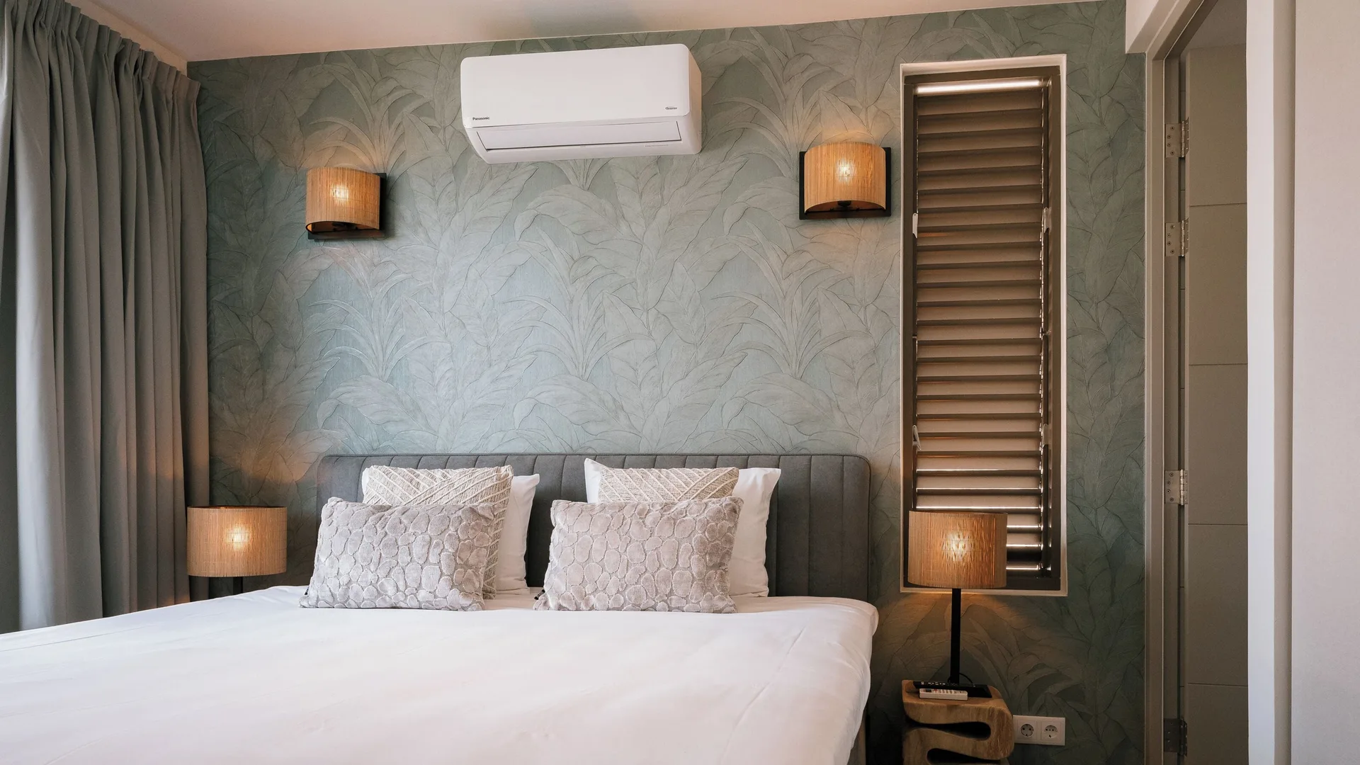 Private Pool Villa bedroom with large bed and green accent wall at Blue Bay Curacao Golf & Beach Resort.