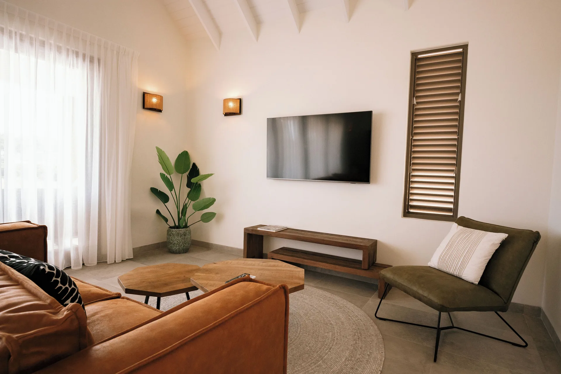 Private Pool Villa living room with sofa and wall TV at Blue Bay Curacao Golf & Beach Resort.