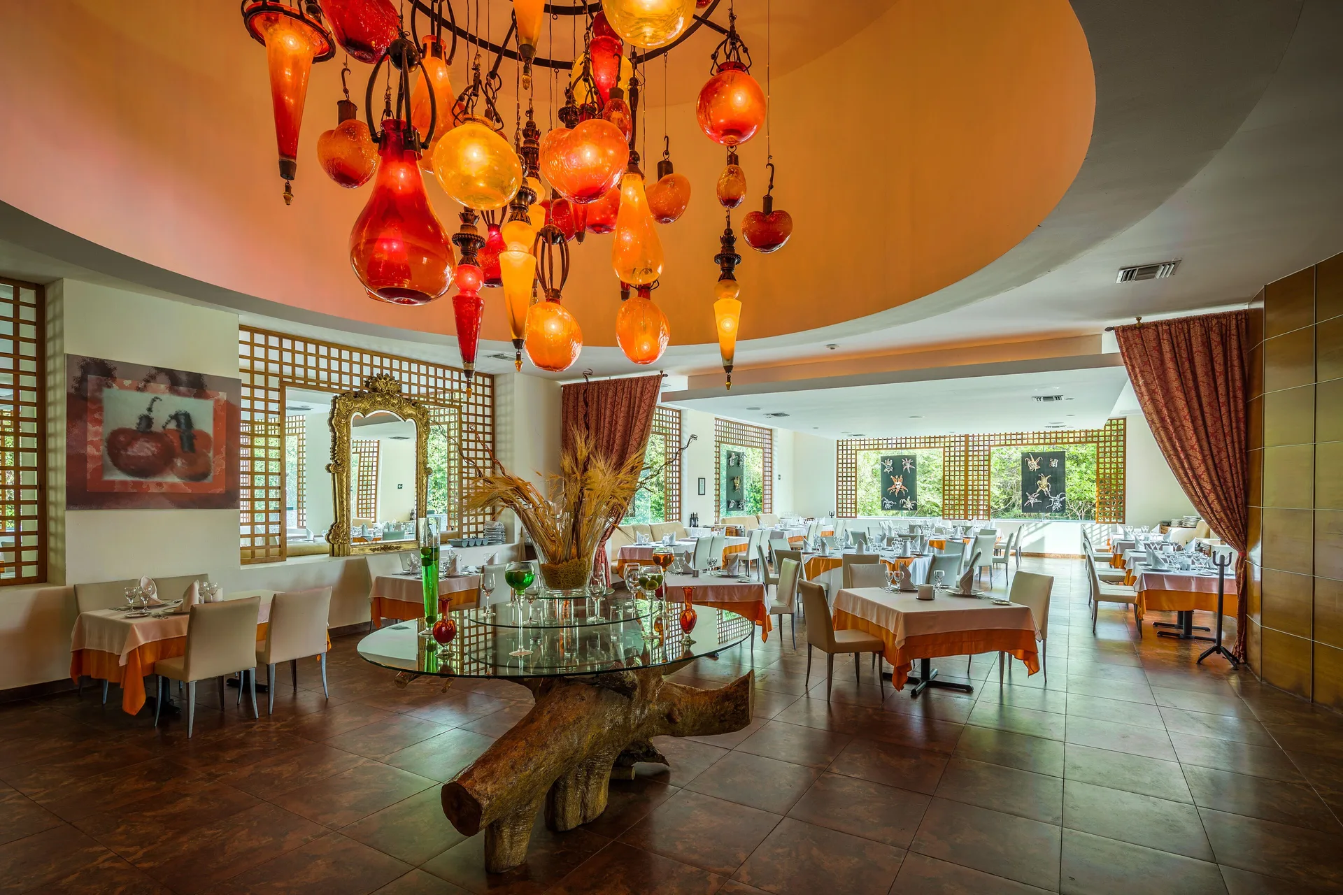 Restaurant dining room with colorful glass chandelier at BlueBay Grand Esmeralda.