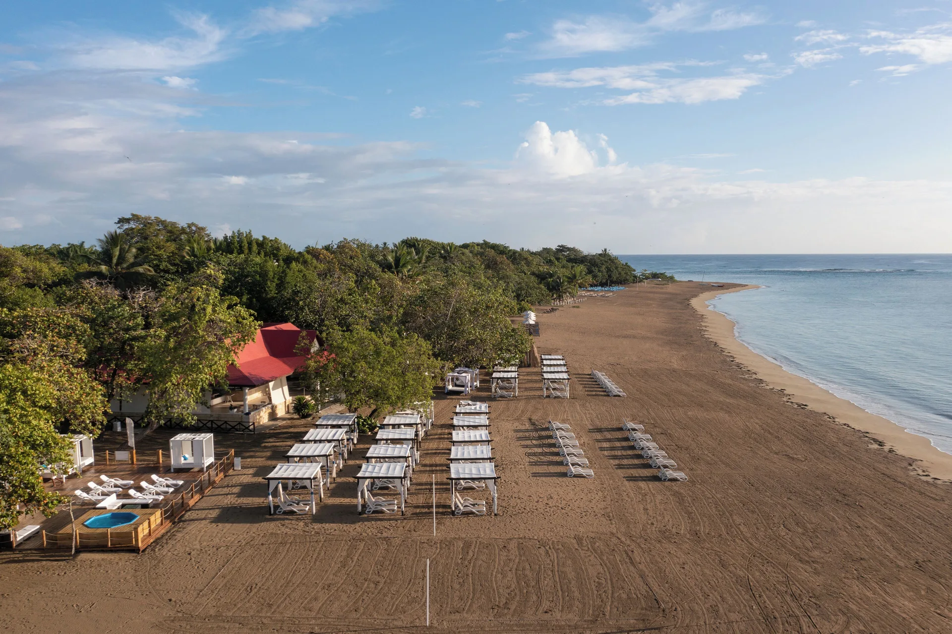 Aerial beach view with loungers and cabanas at BlueBay Villas Doradas.