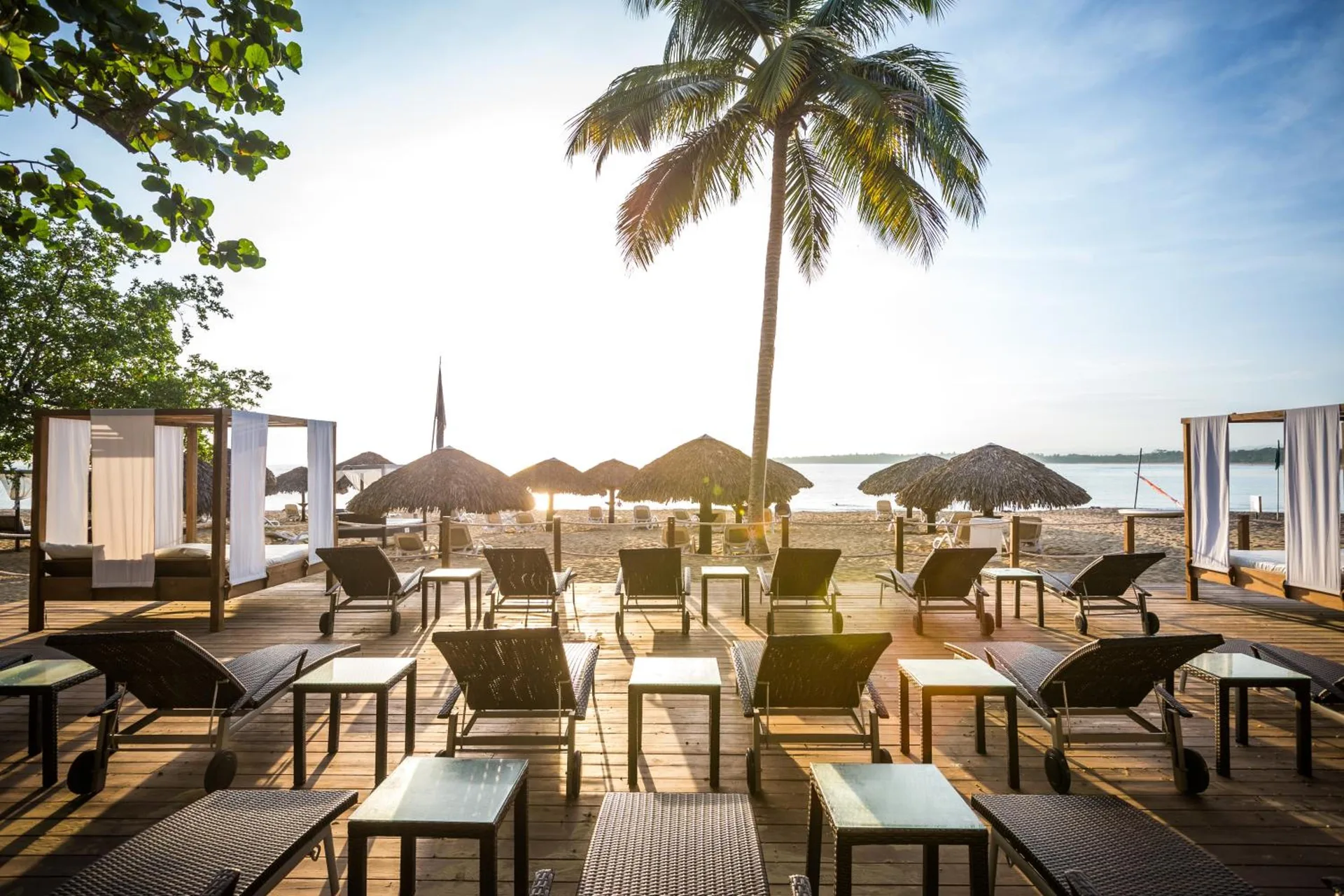 Beach loungers and cabanas face the water at BlueBay Villas Doradas.