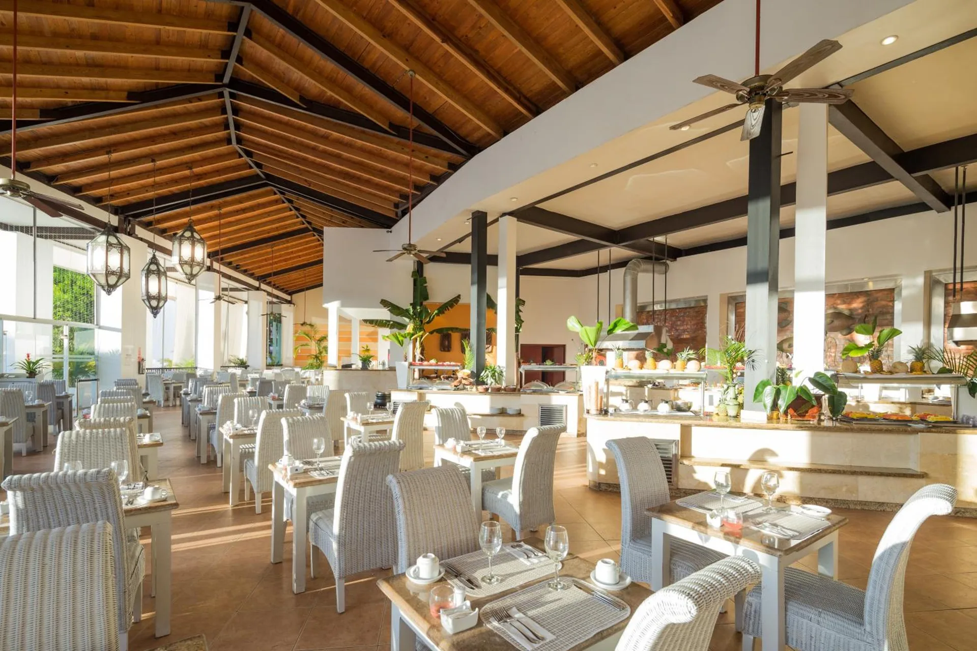 Bright buffet dining room with white wicker chairs at BlueBay Villas Doradas.