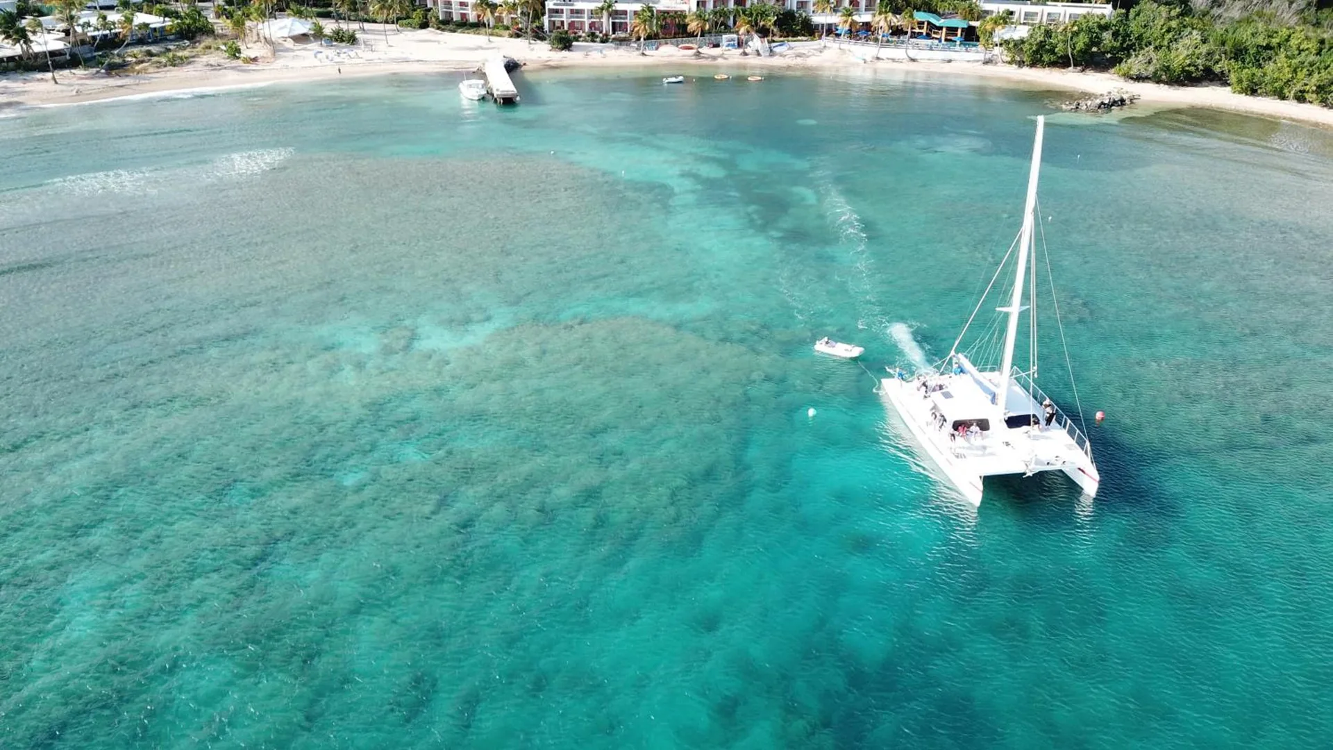 Aerial view of the beach, pier, and catamaran at Bolongo Bay Beach Resort.