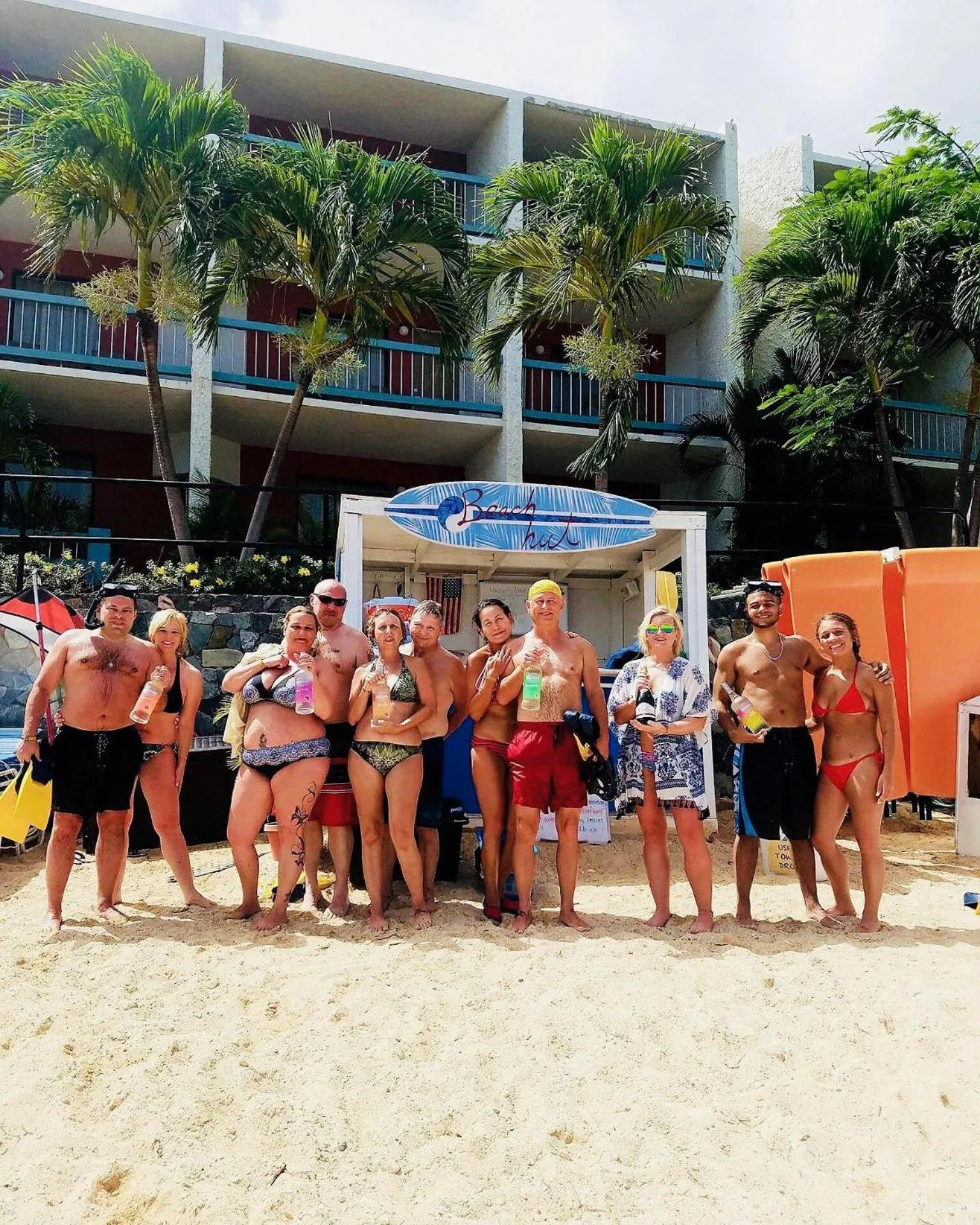 A group poses on the beach in front of resort balconies at Bolongo Bay Beach Resort.
