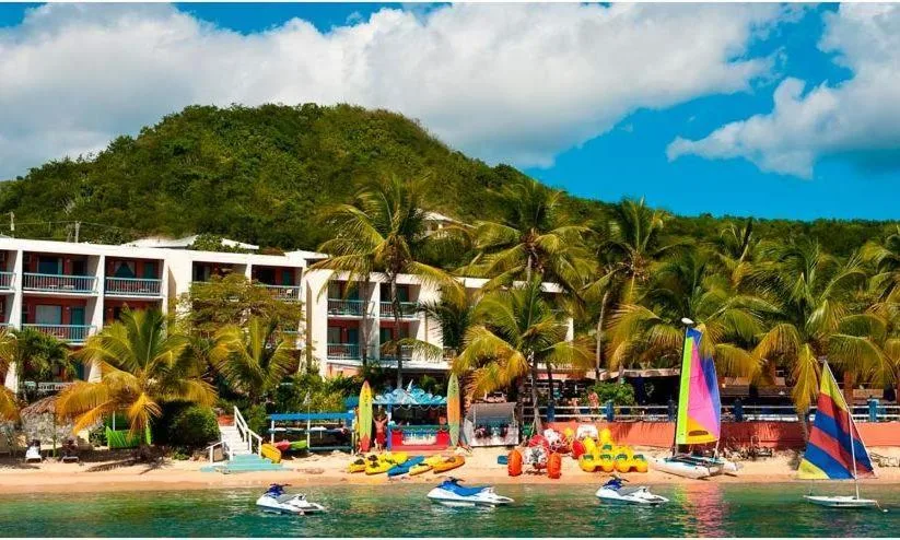 Beachfront buildings, palms, watercraft, and sailboats at Bolongo Bay Beach Resort.
