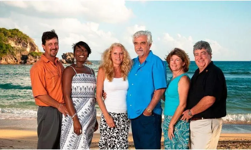Group portrait on the beach with ocean behind them at Bolongo Bay Beach Resort.