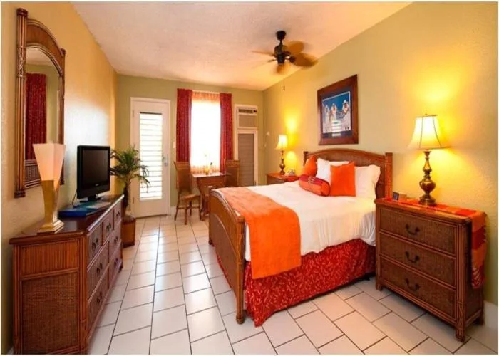 King bed guest room with TV, desk, and exterior door at Bolongo Bay Beach Resort.