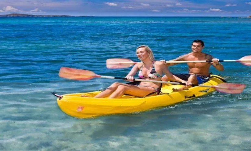 Two guests paddle a yellow kayak in clear blue water at Bolongo Bay Beach Resort.