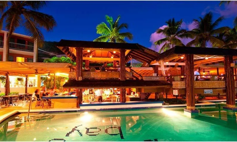 Poolside bar and open-air seating lit at night at Bolongo Bay Beach Resort.