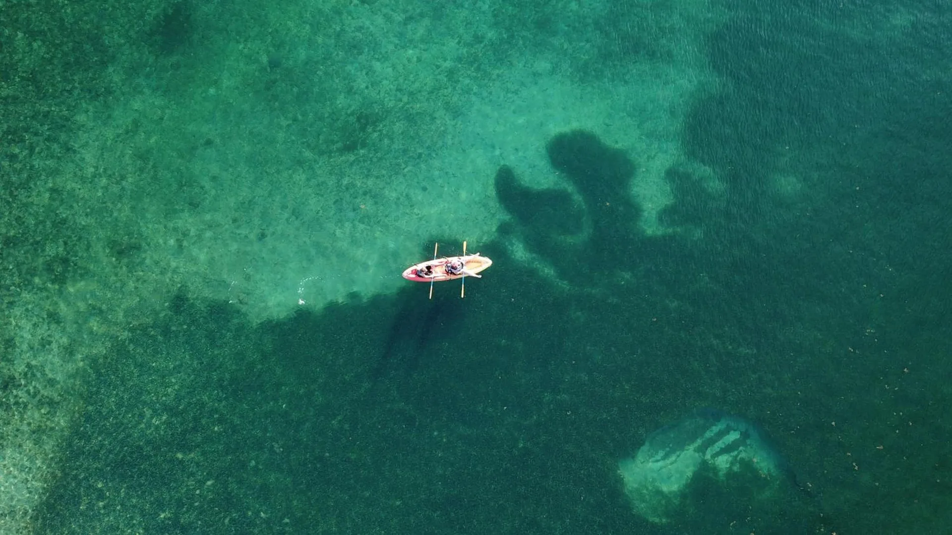 Aerial view of a small rowboat over clear turquoise water at Bolongo Bay Beach Resort.