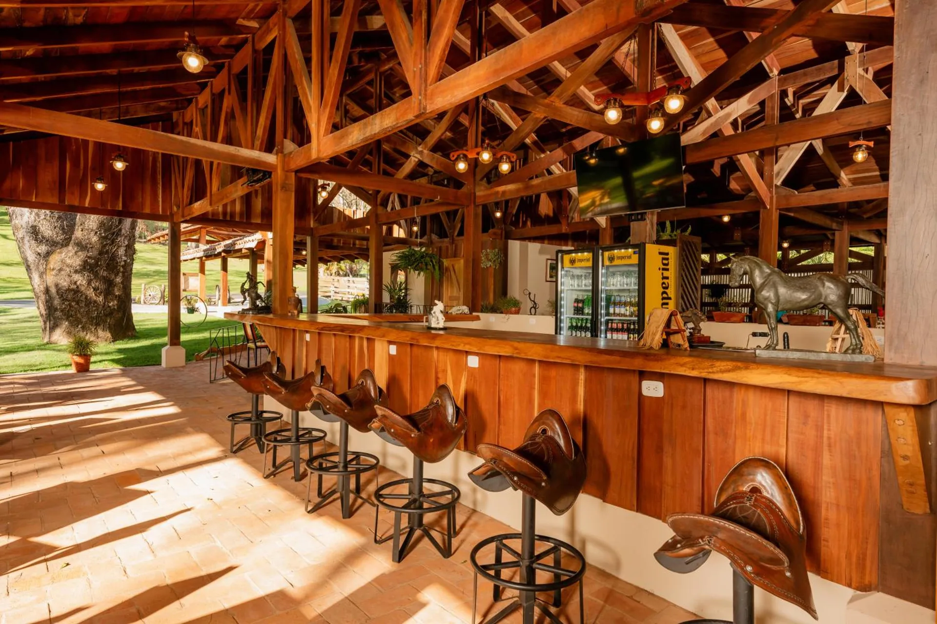 Open-air bar with saddle stools and a wooden counter at Borinquen Thermal Resort.
