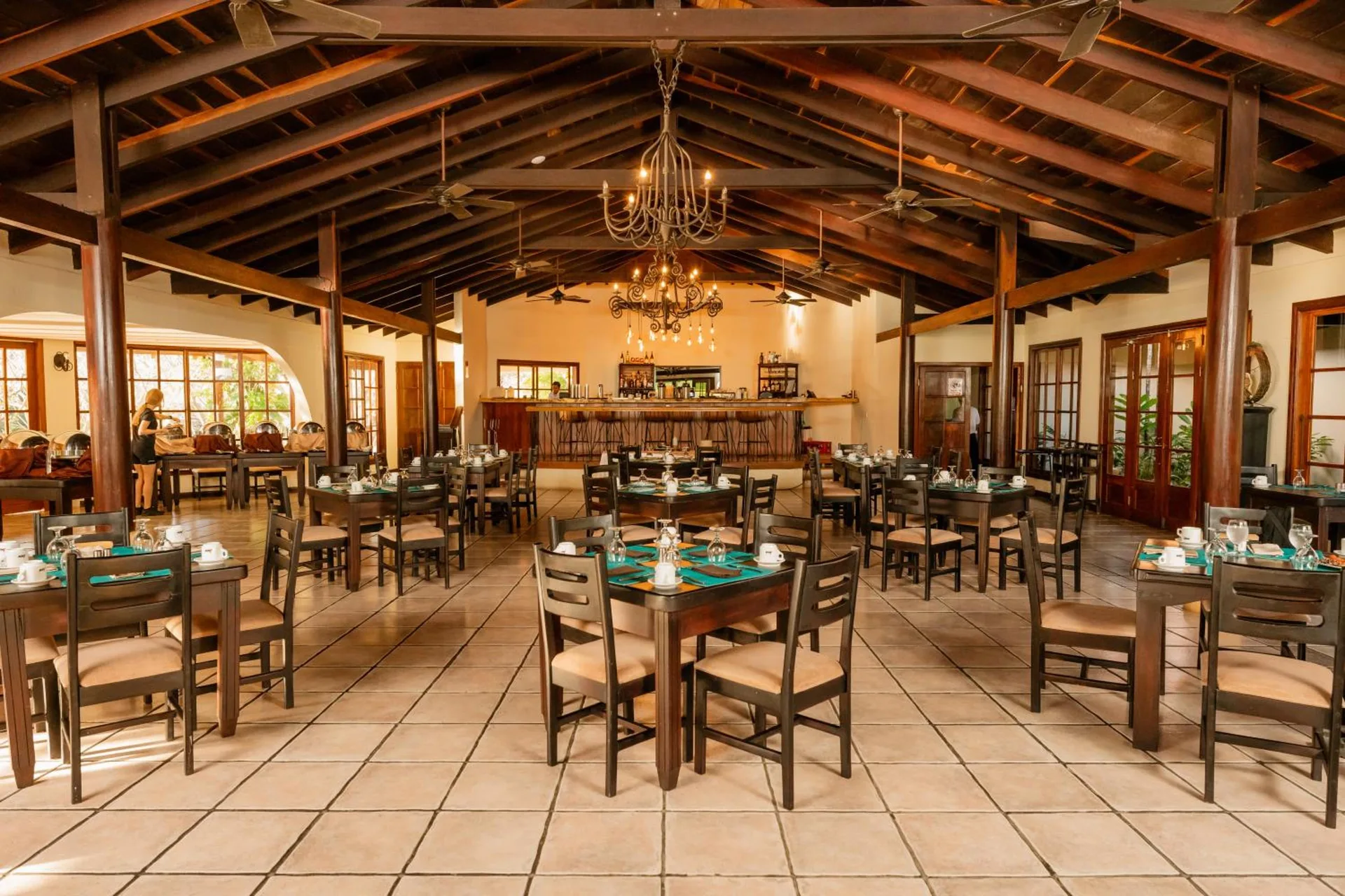 Restaurant dining room with set tables and chandeliers at Borinquen Thermal Resort.