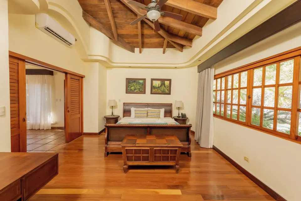 Junior Suite bedroom with wood ceiling and large windows at Borinquen Thermal Resort.