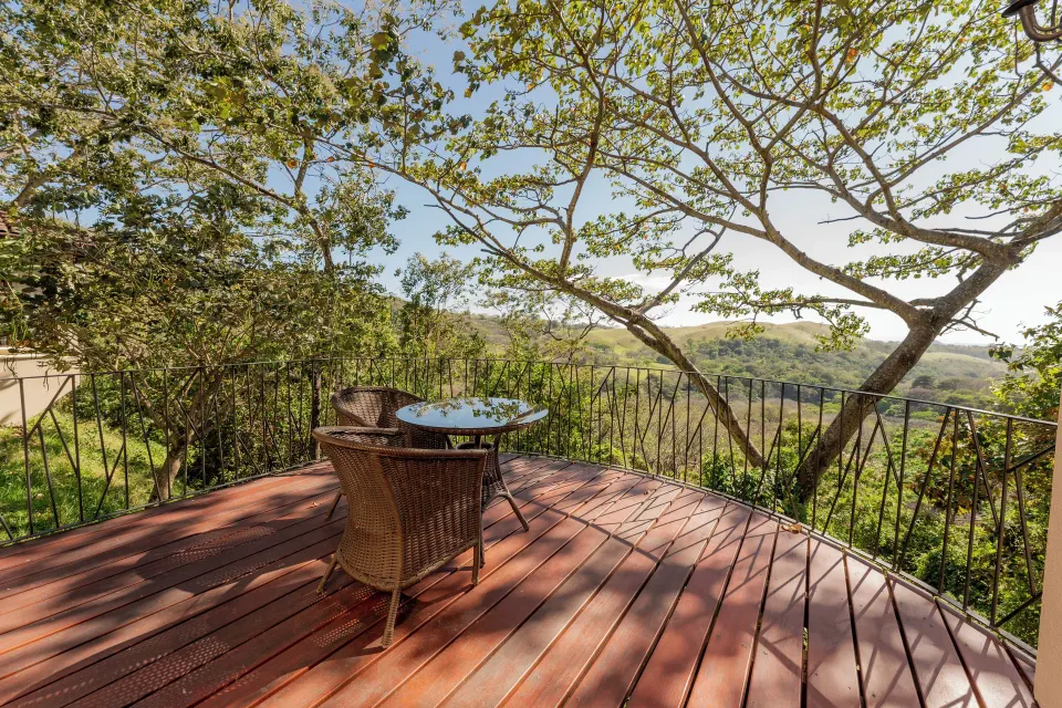 Junior Suite terrace with table, chairs, and mountain view at Borinquen Thermal Resort.
