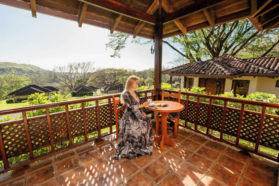 Standard Bungalow balcony with table and mountain views at Borinquen Thermal Resort.
