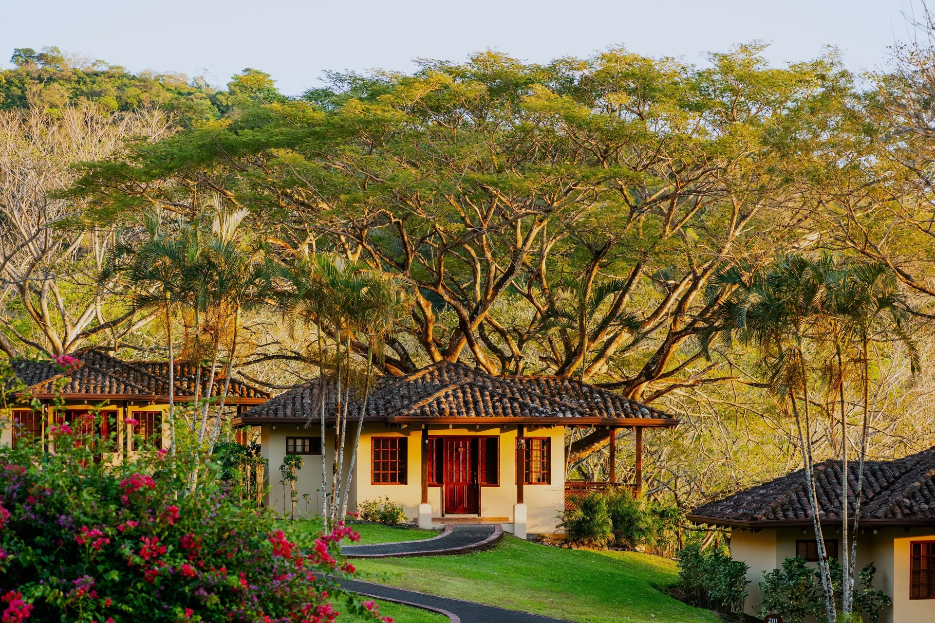 Standard Bungalow exterior among gardens and trees at Borinquen Thermal Resort.