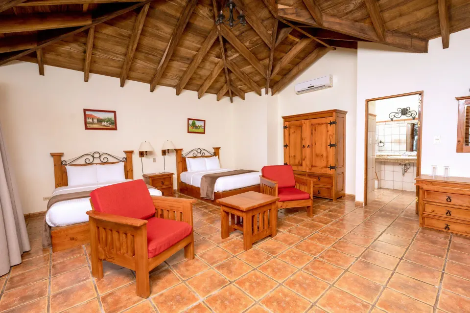 Standard Bungalow room with two beds and wood ceiling at Borinquen Thermal Resort.