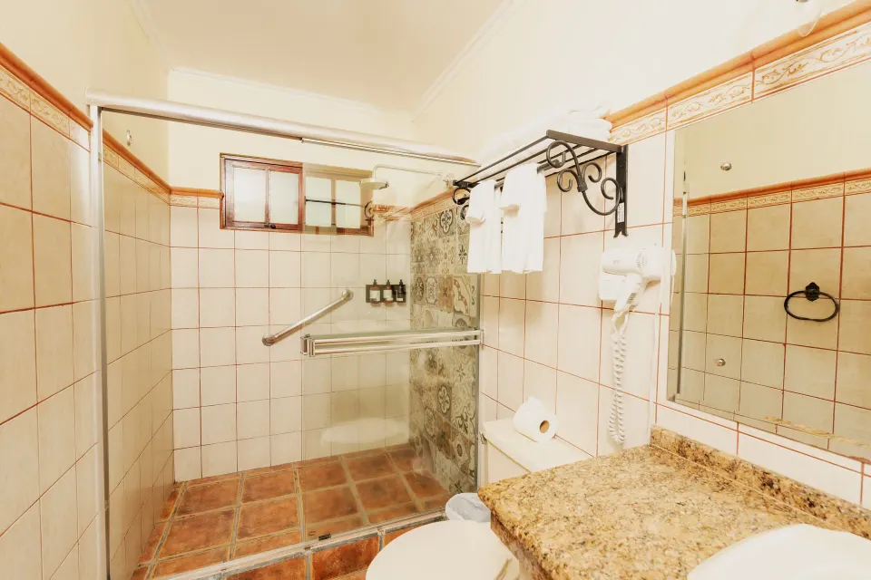 Superior Bungalow bathroom with glass shower and vanity at Borinquen Thermal Resort.