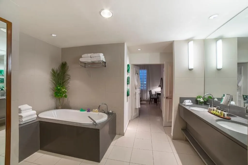 Beach balcony suite bathroom at Carlisle Bay with soaking tub, double vanity and towels.