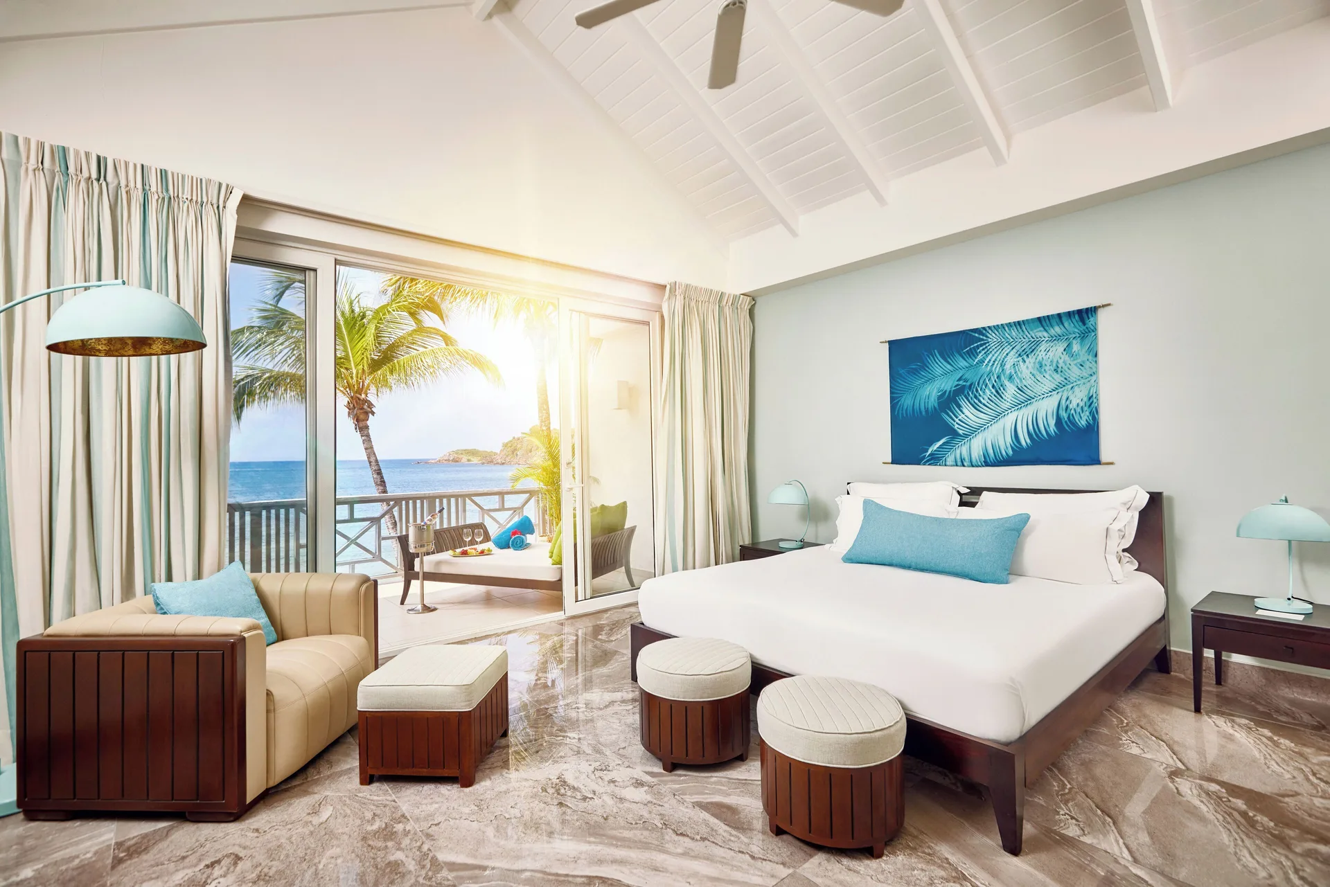 Carlisle Bay suite bedroom with a king bed, vaulted ceiling and ocean-view balcony.