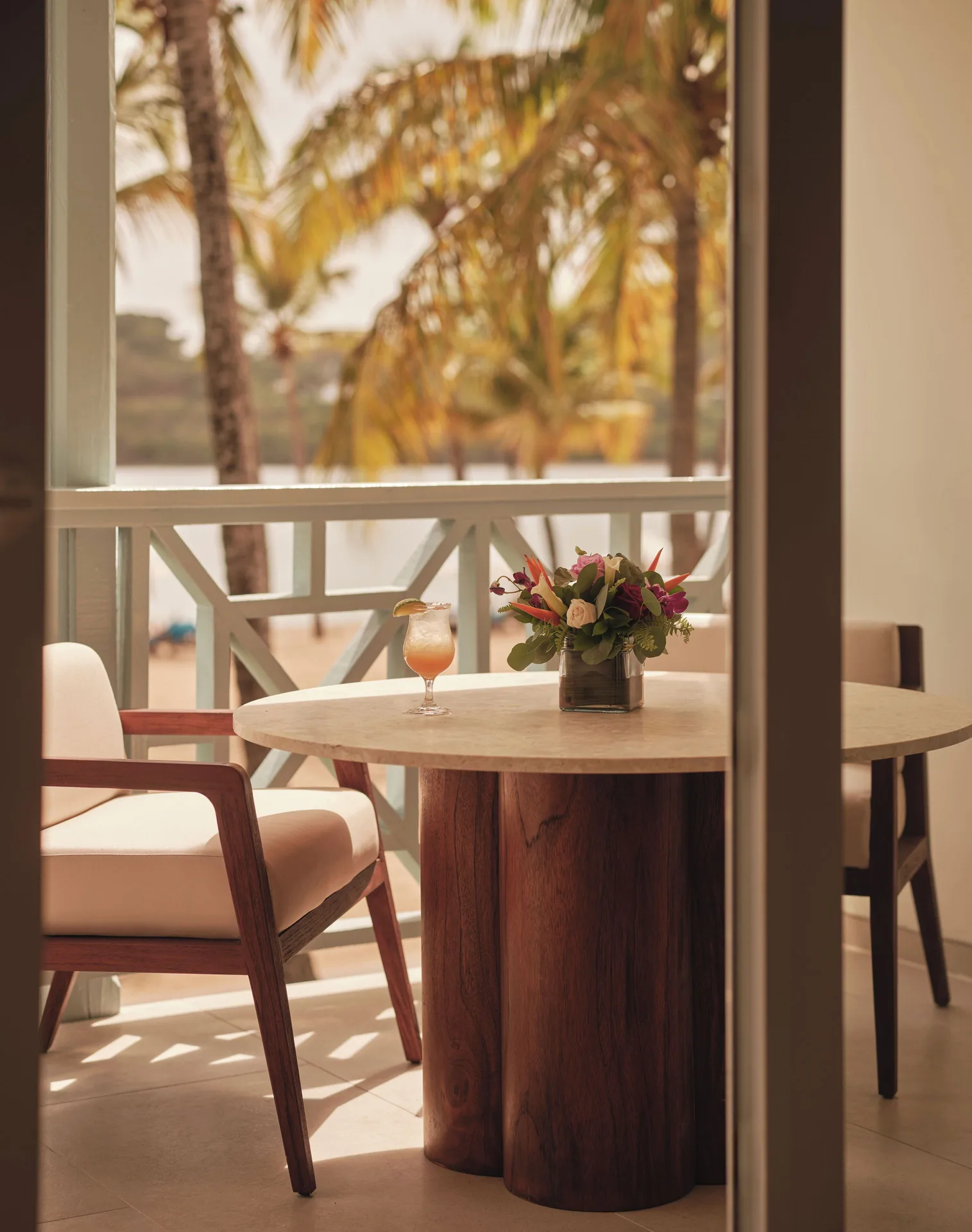 Ocean Suite balcony table with flowers and palm view at Carlisle Bay.