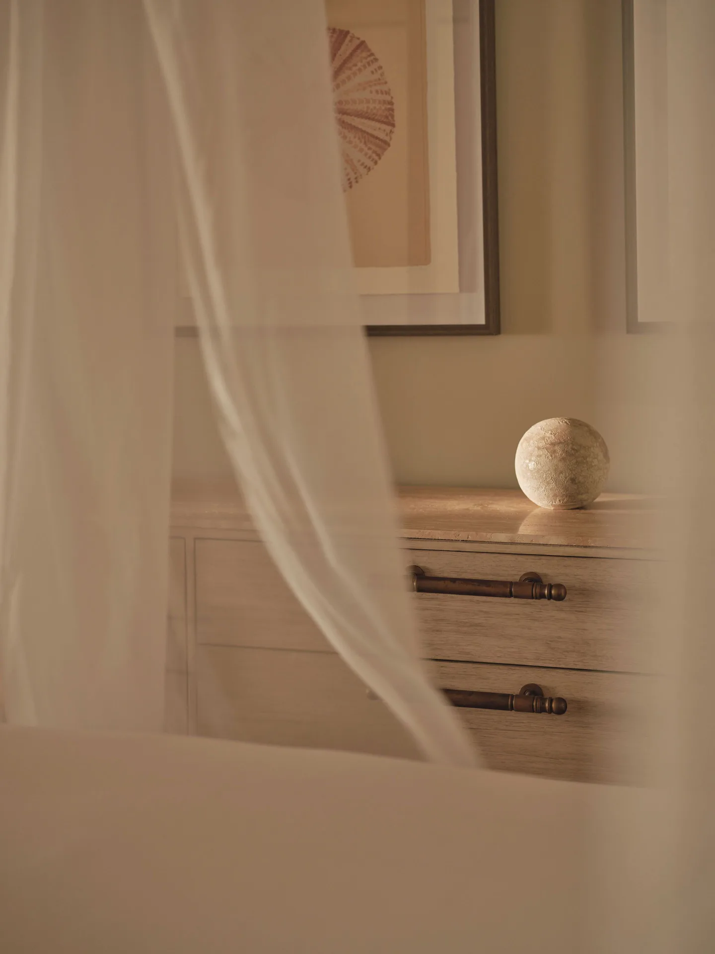 Sheer bed drape and bedside chest in an Ocean Suite at Carlisle Bay.