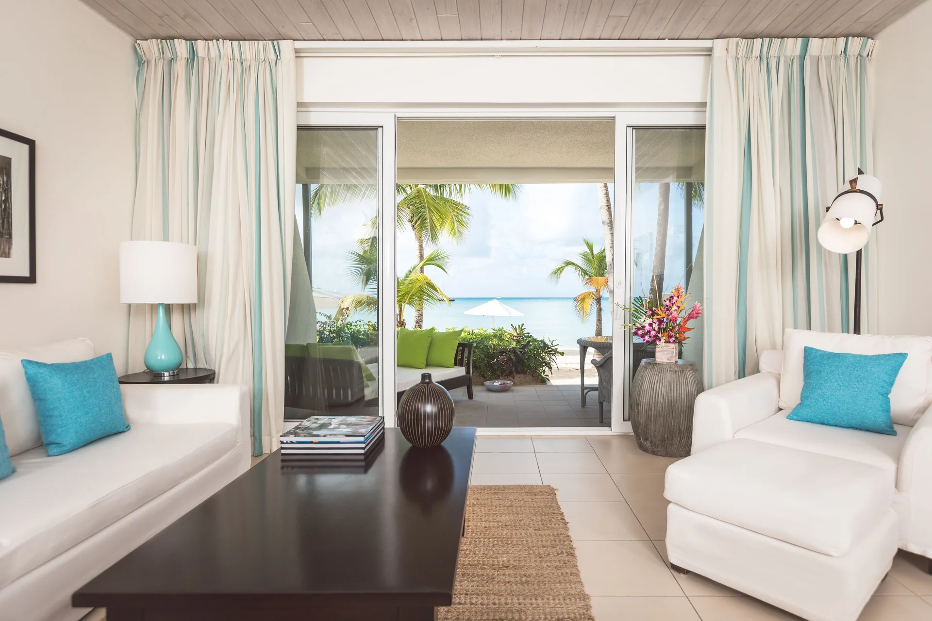 Sitting area in a Terrace beach suite at Carlisle Bay with sliding doors to the beach.