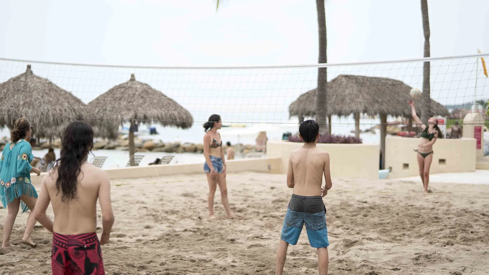 Guests playing beach volleyball on the sand at Club Regina Puerto Vallarta.
