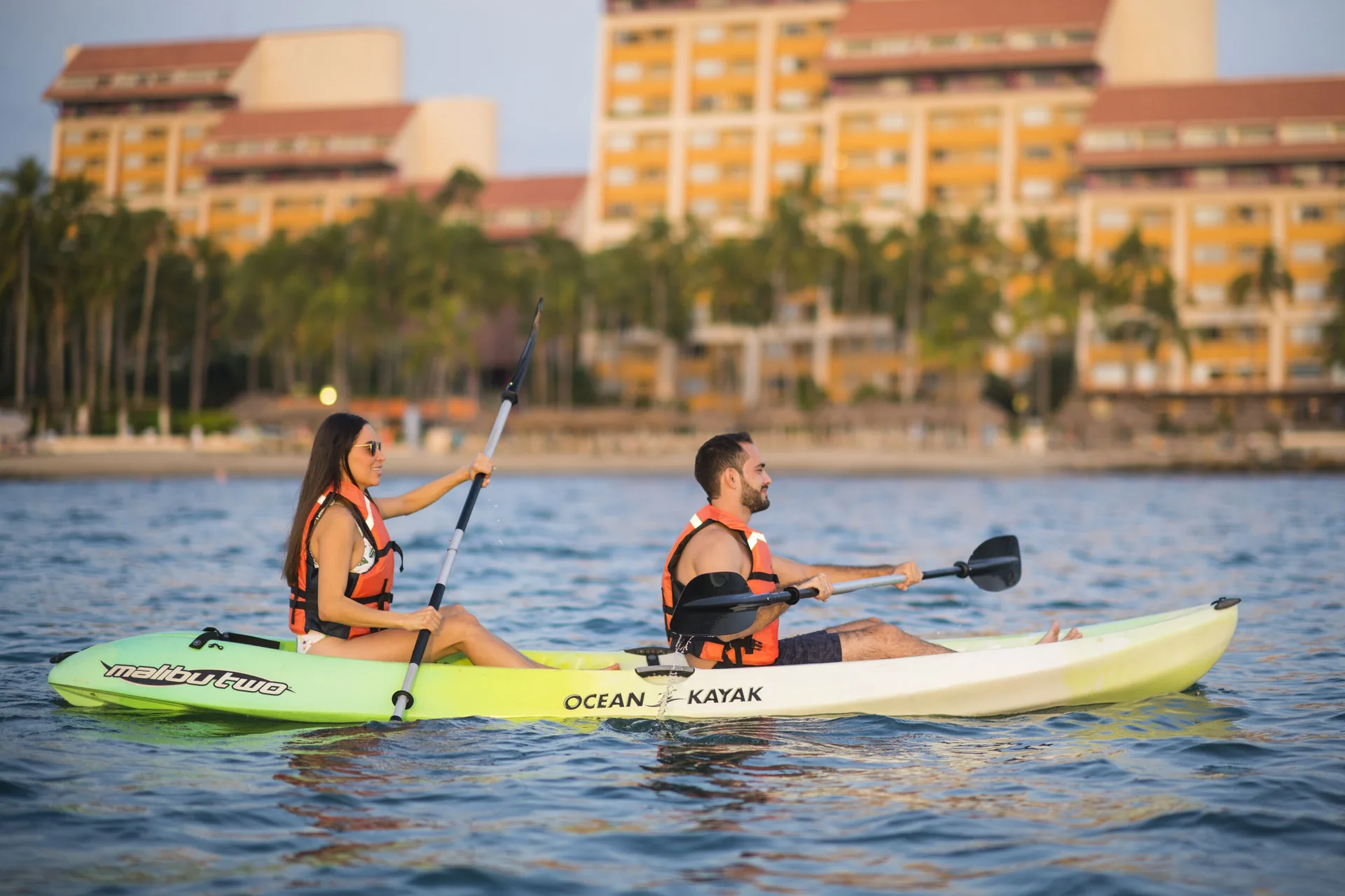 Two guests kayaking on the water in front of Club Regina Puerto Vallarta.