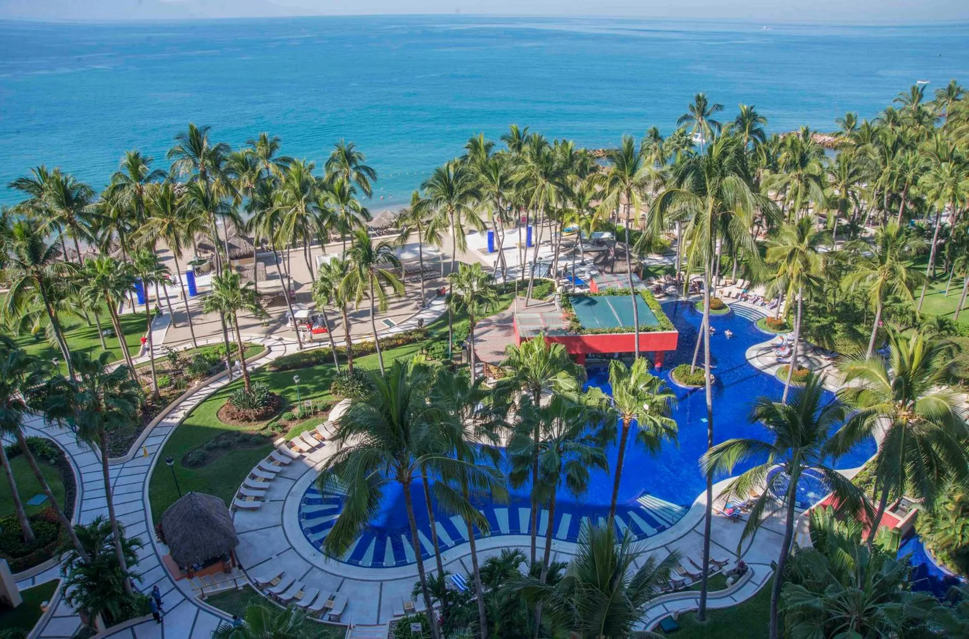 Club Regina Puerto Vallarta pools and palm-lined grounds beside the ocean.