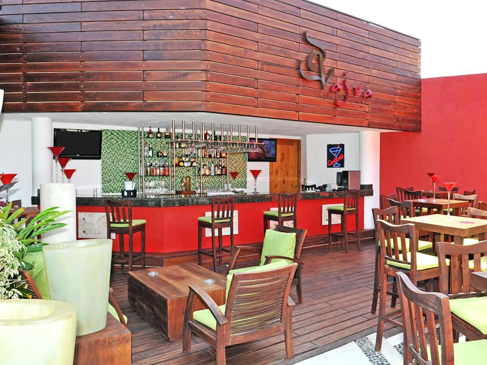 Bar Vajra with red bar front and wood seating at Club Regina Puerto Vallarta.