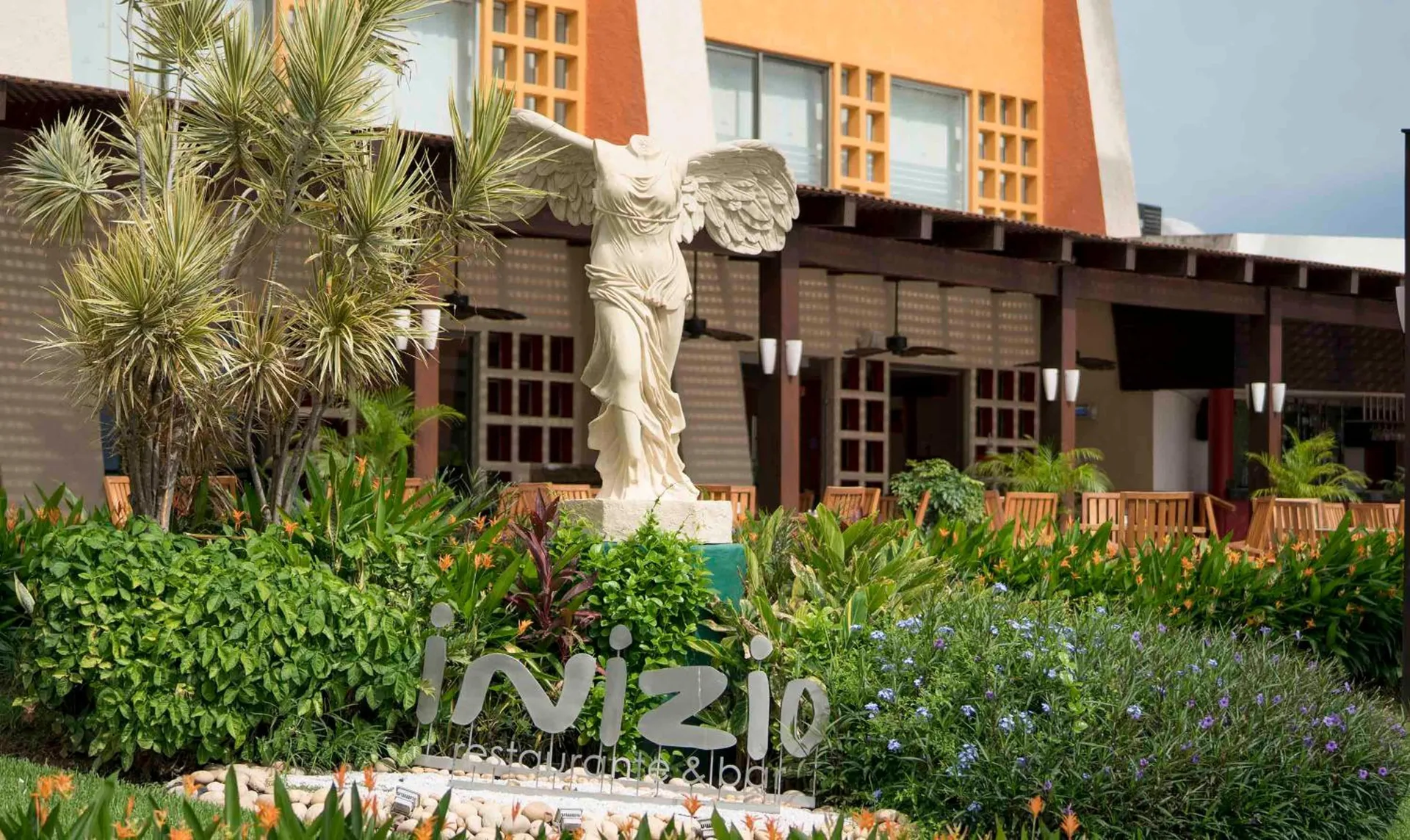 Inizio restaurant garden sign and winged statue at Club Regina Puerto Vallarta.