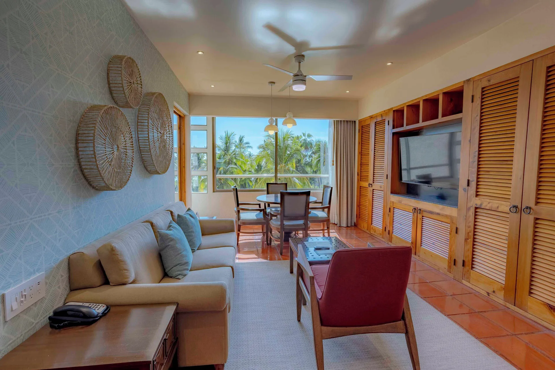 Deluxe suite living area with dining table and garden-view windows at Club Regina Puerto Vallarta.