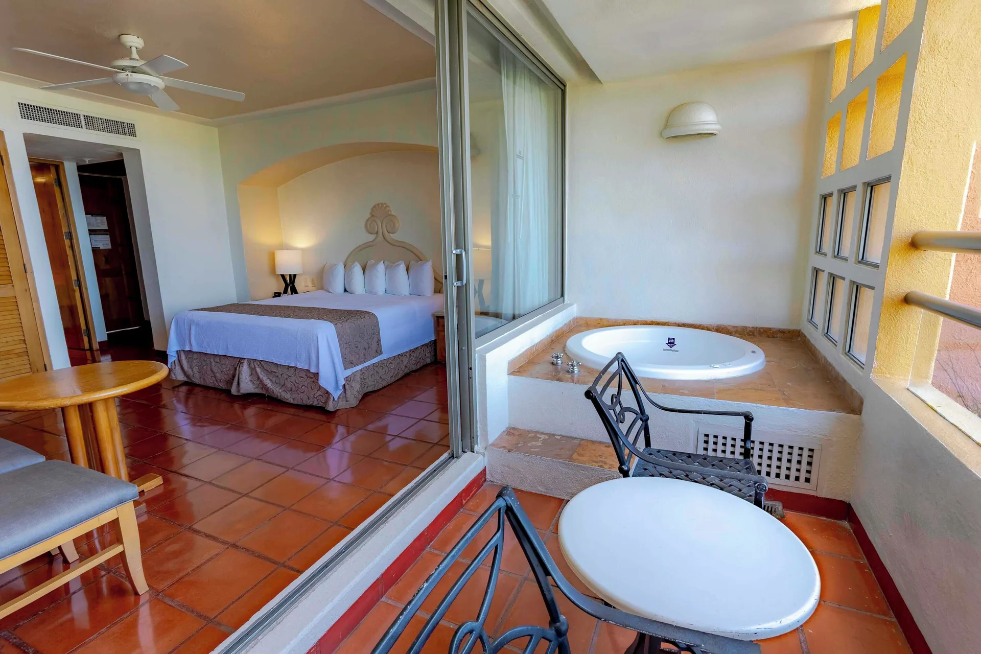 Suite balcony with whirlpool tub and king bedroom at Club Regina Puerto Vallarta.