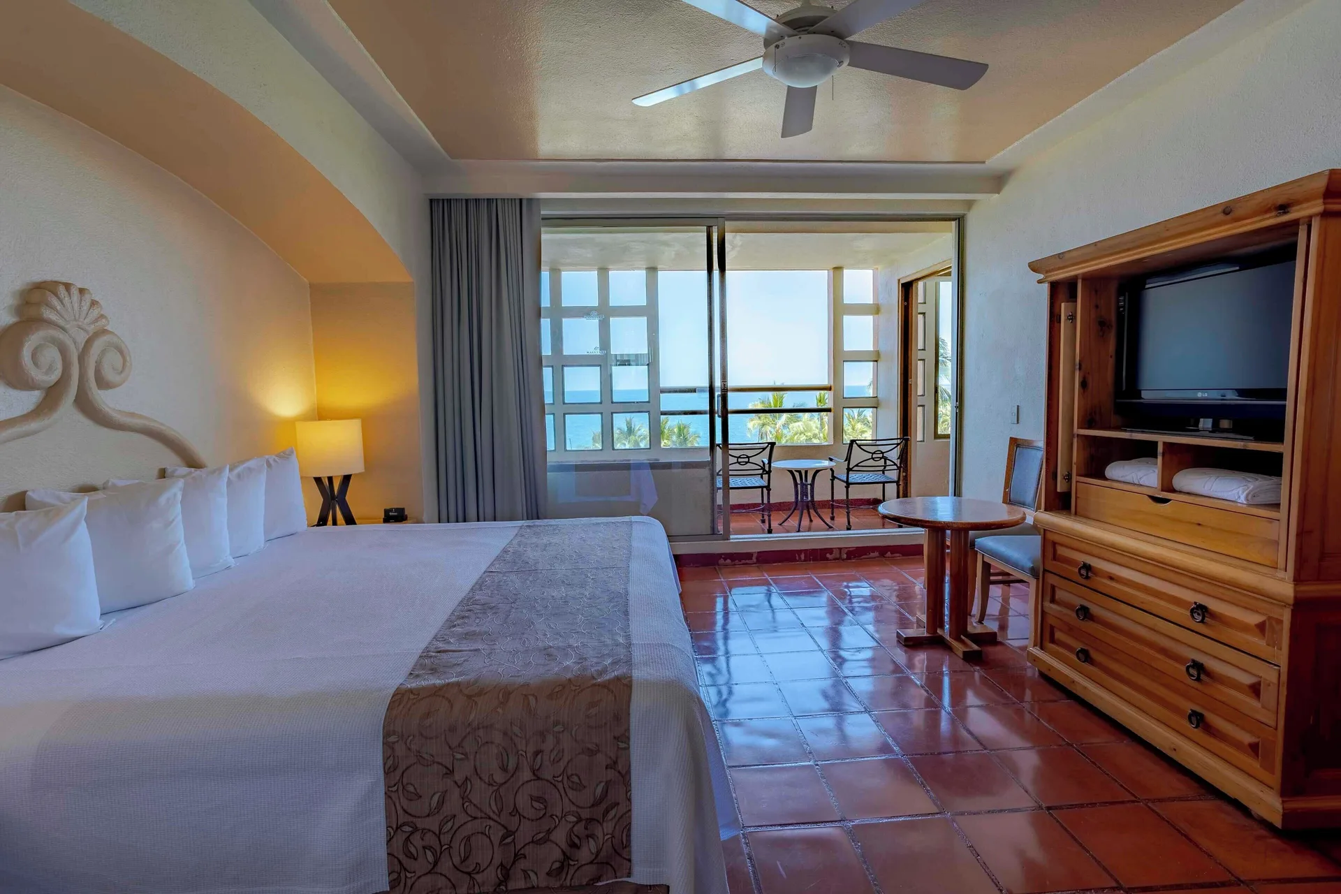 Ocean view suite bedroom with king bed and balcony at Club Regina Puerto Vallarta.